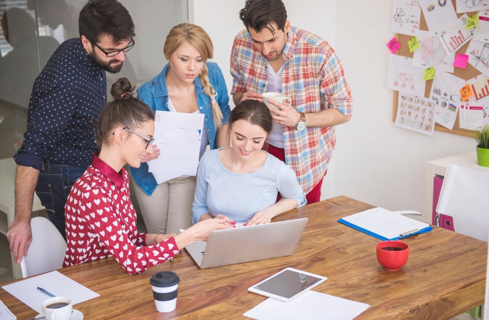 Arbeitsplatz mit Laptop, Notizbuch und Unterlagen zur Geschäftsentwicklung